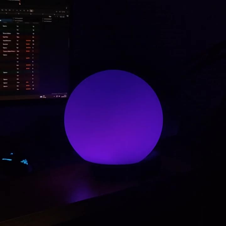 The orb glowing purple in a dark room